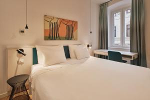 a bedroom with a large white bed and a window at URBANAUTS STUDIOS Ginnastica in Trieste