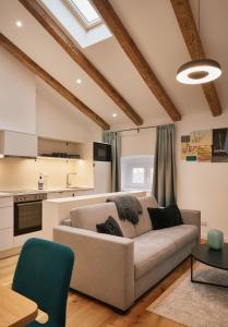 a living room with a couch and a kitchen at URBANAUTS STUDIOS Ginnastica in Trieste