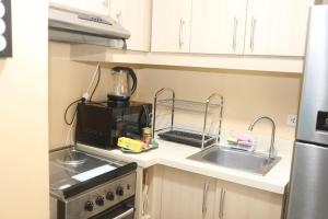 a kitchen with a sink and a blender on a counter at The Mosaic Tower in Manila +3 photos