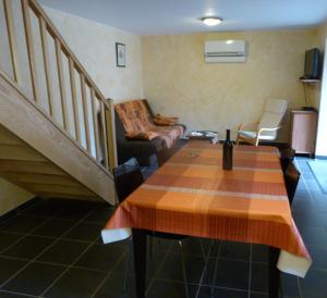 a living room with a table and a staircase at Oustalou in Belcastel