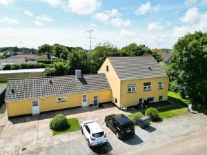 a yellow house with a truck parked in front of it at FeWo Lille Vidstrup in Vidstrup