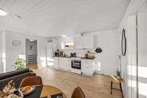 a kitchen and living room with a couch and a table at FeWo Lille Vidstrup in Vidstrup