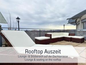 a rooftop patio with a couch and a ramp at Panorama Penthouse mit Dachterrasse - Sauna & Whirlpool in Karlsruhe