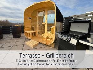 a wooden gazebo on a roof with a grill at Panorama Penthouse mit Dachterrasse - Sauna & Whirlpool in Karlsruhe