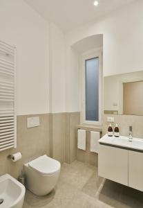 a white bathroom with a toilet and a sink at URBANAUTS STUDIOS Ginnastica in Trieste +27 photos