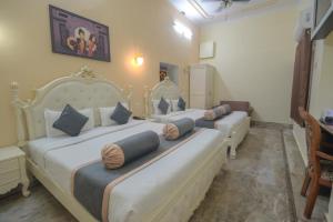 a bedroom with two beds with pillows on them at Shree Ganesha Palace Near Kashi Vishwanath Temple in Varanasi