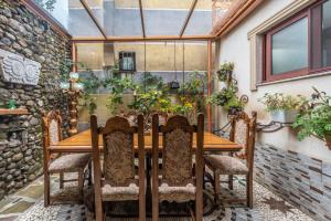 a wooden table and chairs on a patio with plants at Kanuni Authentic Albanian House by PikHost in Shkodër