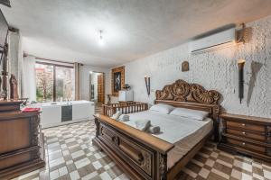 a bedroom with a large bed and a bath room at Kanuni Authentic Albanian House by PikHost in Shkodër
