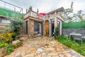 a house with a wooden door and a patio at Kanuni Authentic Albanian House by PikHost in Shkodër