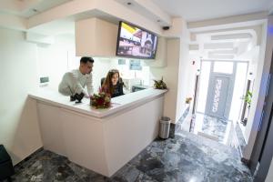 a man and woman sitting at a counter in a kitchen at Pyrgiou suites in Thessaloniki