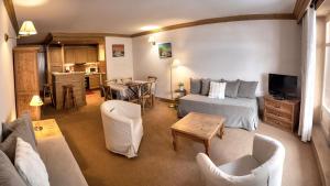 a bedroom with a bed and a living room with a table at Chalet Les Alpes in Val-d'Isère