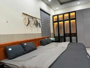 ein großes Bett mit zwei Kissen in einem Zimmer in der Unterkunft Mini Villa in La Gi