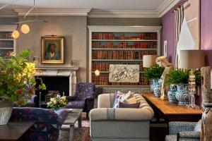 a living room with a couch and a table at Haymarket Hotel, Firmdale Hotels in London