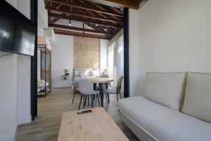 a living room with a couch and a table at Escolástica Suites Centro in Granada