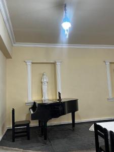 a piano in a room with a statue and a chandelier at AparanQ