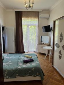 a bedroom with a bed and a dresser and a window at Kobuleti stay inn in Kobuleti