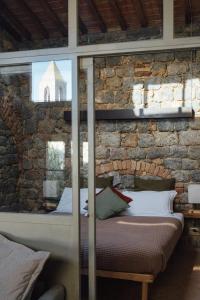 a bed in a room with a stone wall at Fattoria San Donato in San Gimignano