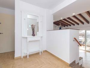 a white room with a vase of flowers on a shelf at Villa Gavines Up in S'Algar +43 photos