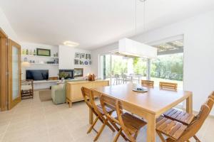 a dining room and living room with a table and chairs at Biniancolla Heura in Biniancolla
