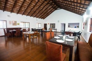 ein Restaurant mit Tischen und Stühlen in einem Raum in der Unterkunft The Nest Bettathur, Coorg in Madikeri