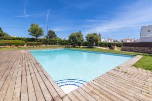 a swimming pool in a yard with a wooden deck at Biniancolla Heura in Biniancolla