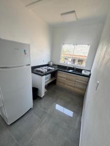 a small kitchen with a refrigerator and a sink at Casa nova em Torres in Torres