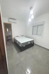 a bedroom with a bed in the corner of a room at Casa nova em Torres in Torres