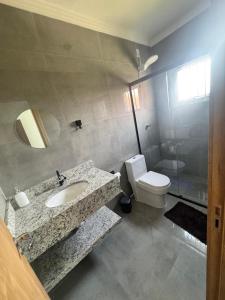 a bathroom with a sink and a toilet at Casa nova em Torres in Torres