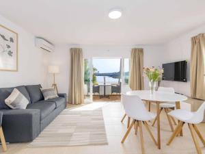 a living room with a couch and a table at Villa Gavines down in S'Algar