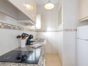 a small kitchen with a sink and a refrigerator at Villa Gavines down in S'Algar