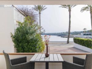a table and chairs with a vase on a table at Villa Gavines down in S'Algar