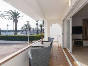 a balcony with a table and chairs and palm trees at Villa Gavines down in S'Algar +18 photos