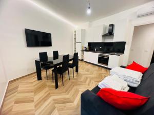 a living room with a couch and a table with chairs at Suite Borgo 112 - Sanremo in Sanremo