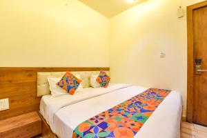 a bedroom with a large bed with colorful pillows at FabHotel Aishwarya in Kota