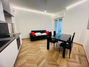 a living room with a table and a black couch at Suite Borgo 112 - Sanremo in Sanremo