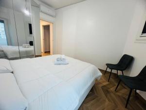 a bedroom with a large white bed and a chair at Suite Borgo 112 - Sanremo in Sanremo +8 photos