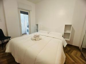 a bedroom with a white bed with two certificates on it at Suite Borgo 112 - Sanremo in Sanremo