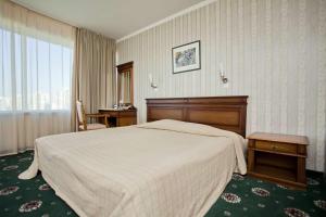 a hotel room with a large bed and a window at Mirage Hotel in Burgas
