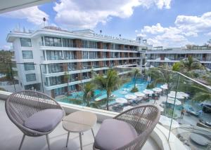 a balcony with chairs and a view of a hotel at Beachfront 267 3BR Condo with Pool View in Phuket