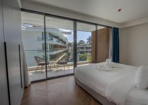 a bedroom with a bed and a balcony at Beachfront 267 3BR Condo with Pool View in Phuket +39 photos
