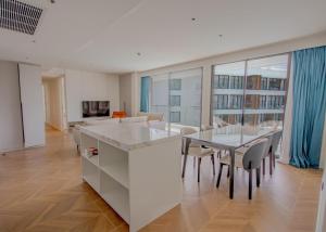 a kitchen and dining room with a table and chairs at Beachfront 267 3BR Condo with Pool View in Phuket