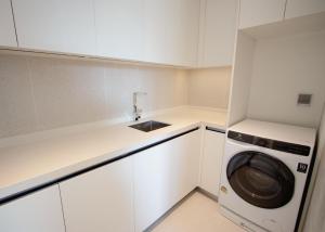 a kitchen with a washing machine and a sink at Beachfront 267 3BR Condo with Pool View in Phuket