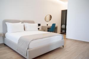 a bedroom with a white bed and a blue chair at Villa Guesthouse Albion in Lezhë +98 photos