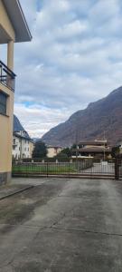 a building with a fence and mountains in the background at Casa Colomba a Tirano in Tirano
