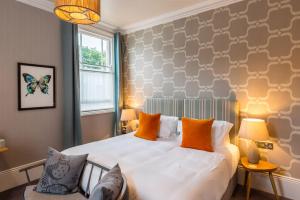 a bedroom with a large white bed with orange pillows at The High Field Town House in Birmingham