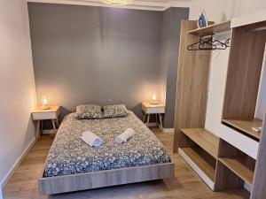 a small bedroom with a bed and two tables at Faubourg des voyageurs 6 - T3 climatisé 4 personnes - proche axe autoroute et gare in Saran
