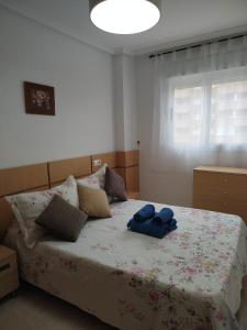 a bedroom with a bed with two blue towels on it at Marina Dor holidays in Oropesa del Mar
