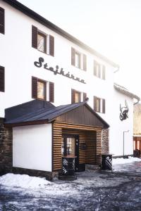 a white building with a sign on the side of it at Stejkárna Špičák in Špičák