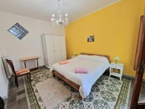 a bedroom with a bed and a yellow wall at A Casa da Vita in Chiaramonte Gulfi
