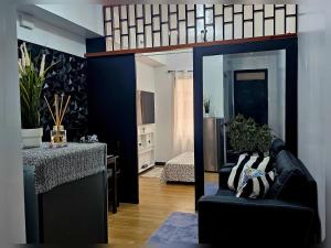 a living room with a black couch and a table at Paseo Verde Condo Unit in Las Pinas - Sleeps 2 Adults & 2 Children in Manila +13 photos
